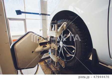 A Car on the Car Steering Wheel Balancer and Calibrate with laser reflector attach on each tire to A Car on the Car Steering Wheel Balancer and Calibrate with laser reflector attach on each tire to 47944470