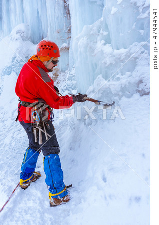 climber doing steps in the ice with an ice ax climber doing steps in the ice with an ice ax 47944541