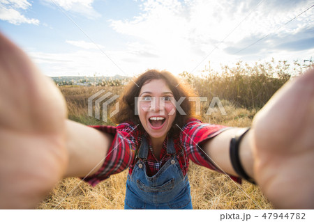 Travel, vacation and holiday concept - Funny young woman taking selfie over beautiful landscape Travel, vacation and holiday concept - Funny young woman taking selfie over beautiful landscape 47944782