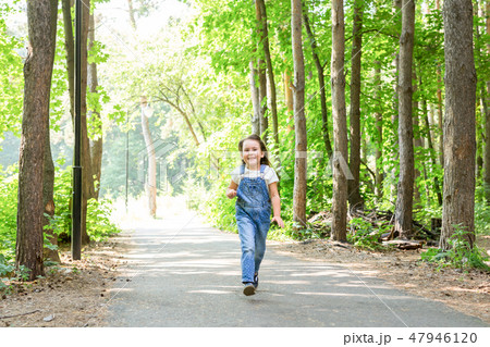 Children, childhood, people concept - little happy child girl walking in summer park 47946120