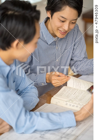 改正建築士法が公布に合わせて若手の人材育成に力を入れ一級建築士の試験勉強を勧める若い男性ビジネスマン 47946309