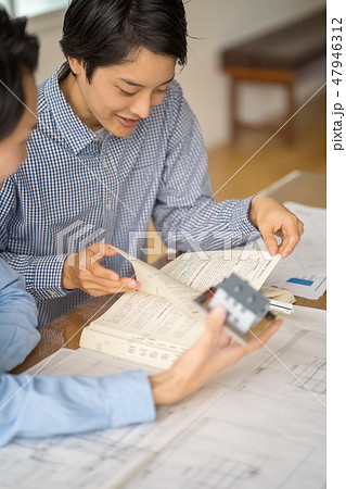 建築基準法施行令を引きながら設計の実務に沿った流れを学習する一級建築士を目指している若い男性社員 建築基準法施行令を引きながら設計の実務に沿った流れを学習する一級建築士を目指している若い男性社員 47946312
