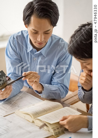 信頼のおける先輩から一級建築士の試験勉強を教えてもらい嬉しそうに楽しく勉強する若い男性会社員 信頼のおける先輩から一級建築士の試験勉強を教えてもらい嬉しそうに楽しく勉強する若い男性会社員 47946330