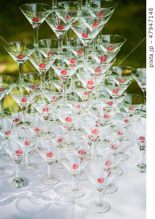 Pyramid of many empty glasses with red cherries Pyramid of many empty glasses with red cherries 47947146