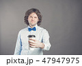 Portrait of happy handsome man in blue shirt and bow tie with paper cup of morning coffee. Good 47947975