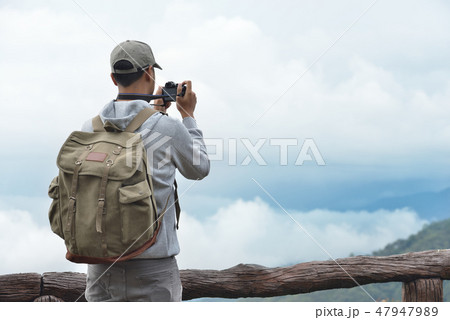 Young man travel photographer taking nature photo 47947989