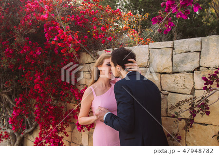 Man and woman together walking and kissing Man and woman together walking and kissing 47948782
