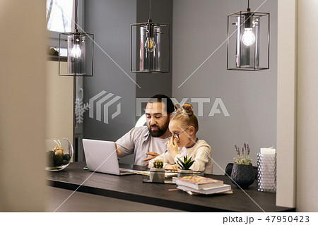Fair-haired pretty girl in a white sweater looking concentrated 47950423