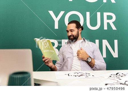 Dark-haired bearded man in a white t-shirt feeling excited 47950496