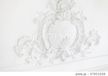 Beautiful ornate white decorative plaster mouldings in studio. The white wall is decorated with 47953209