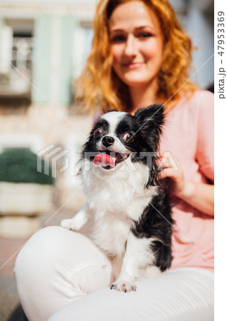The theme is the friendship of man and animal. Beautiful young red hair Caucasian woman holding a 47953369