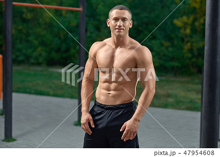 Muscular sportsman with naked torso posing outdoors. 47954608