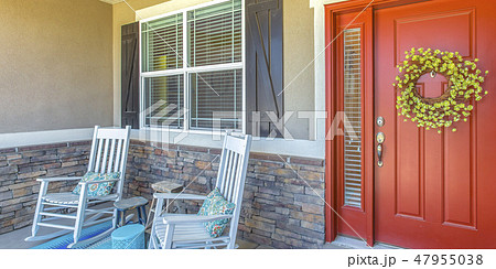 Red front door with wreath and chairs on porch Red front door with wreath and chairs on porch 47955038