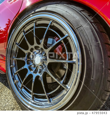 Red car with silver rim on its wheels 47955043