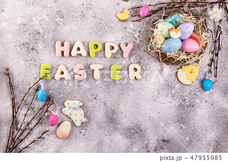 Easter eggs in a nest of grass and homemade glazed cookies on a stone background, flat lay Easter eggs in a nest of grass and homemade glazed cookies on a stone background, flat lay 47955985