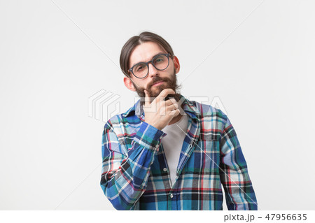 Emotions and people concept - Bearded hipster man thinking about something on white background. Emotions and people concept - Bearded hipster man thinking about something on white background. 47956635