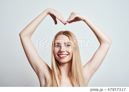 Love is everywhere...Portrait of lovely charming blonde girl making heart figure over head and Love is everywhere...Portrait of lovely charming blonde girl making heart figure over head and 47957317