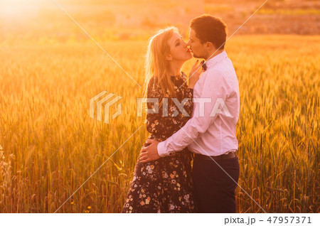 Man and woman embracing and kissing in wheat field Man and woman embracing and kissing in wheat field 47957371