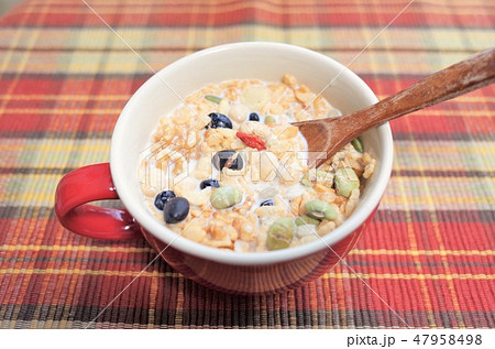 健康的なグラノーラ朝食 ミューズリー 豆乳 赤いランチョンマット 新鮮なシリアル ロハスとロカボ食品の写真素材