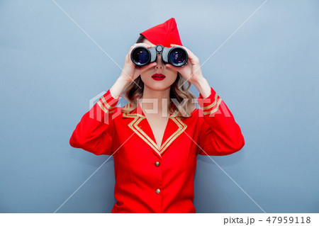 stewardess wearing in red uniform with binoculars stewardess wearing in red uniform with binoculars 47959118