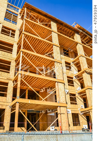 Six storey frame building under construction on concrete foundation bed. Six storey frame building under construction on concrete foundation bed. 47959394