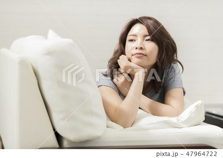 若い女性　ソファー　リラックス　ほおづえ　ライフスタイル 47964722