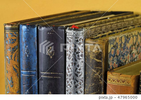 Cultural heritage. Antique books on old wooden shelf. Old books on yellow background. Close up 47965000