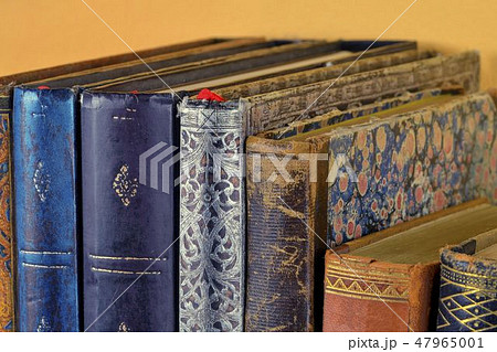 Cultural heritage. Old books on wooden shelf. Antique books on yellow background. Close up 47965001