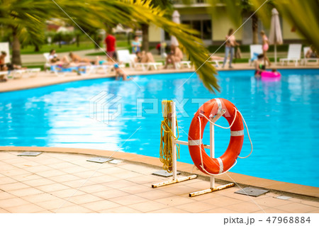 Lifebuoy life ring with rope attached to the post next to the pool in city in tropical country 47968884