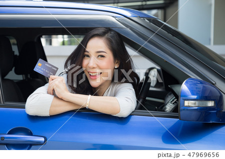Asian woman sitting inside car, show credit card 47969656
