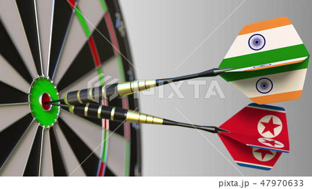 Flags of India and North Korea on darts hitting bullseye of the target. International cooperation or 47970633