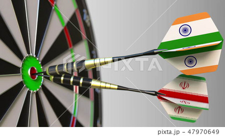 Flags of India and Iran on darts hitting bullseye of the target. International cooperation or 47970649