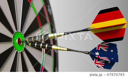 Flags of Germany and Australia on darts hitting bullseye of the target. International cooperation or 47970765