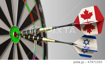 Flags of Canada and Israel on darts hitting bullseye of the target. International cooperation or Flags of Canada and Israel on darts hitting bullseye of the target. International cooperation or 47971505