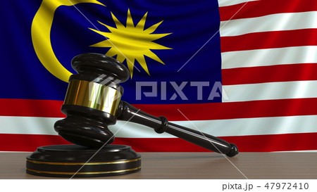 Judge's gavel and block against the flag of Malaysia. Malaysian court conceptual 3D rendering Judge's gavel and block against the flag of Malaysia. Malaysian court conceptual 3D rendering 47972410