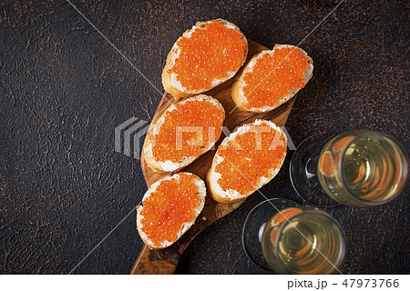 Toasts with red salmon caviar and champagne Toasts with red salmon caviar and champagne 47973766