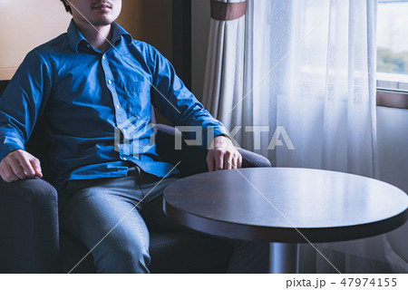 椅子に座った男性 47974155