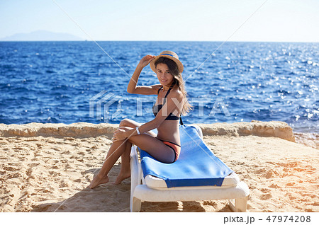 Beautiful woman sunbathing on a beach at tropical travel resort, enjoying summer holidays. Young 47974208