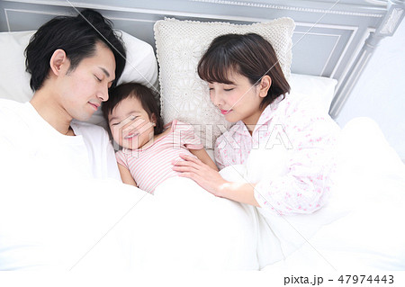 ベッドに入る若い家族 47974443