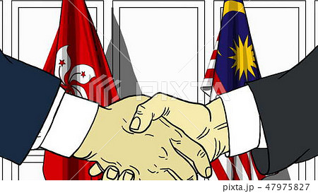 Businessmen or politicians shake hands against flags of Hong Kong and Malaysia. Official meeting or 47975827