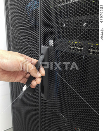 Man open the door of computer server rack 47976582