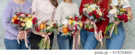 Florist workplace. Woman arranging a bouquet with roses, chrysanthemum, carnation and other flowers 47976860