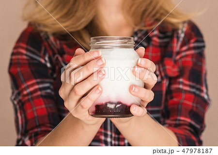 Girl holding a jar with sweet homemade yogurt Girl holding a jar with sweet homemade yogurt 47978187