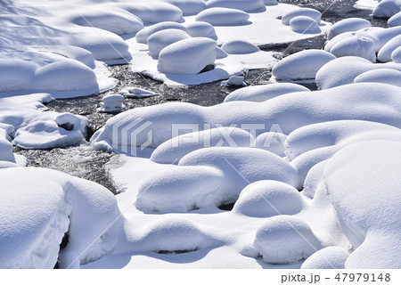 冬の北海道八雲町八熊峠の峠下で遊楽部川の河原の岩に大雪が積もりモコモコした風景を撮影 47979148