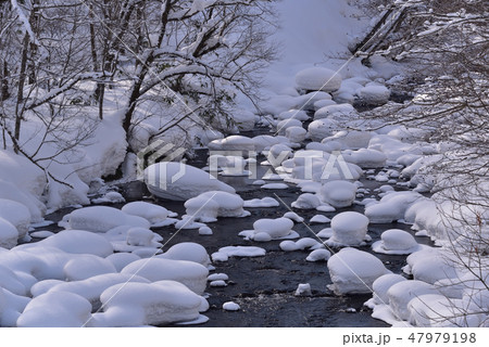 冬の北海道八雲町八熊峠の峠下で遊楽部川の河原の岩に大雪が積もりモコモコした風景を撮影 47979198