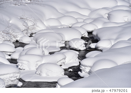 冬の北海道八雲町八熊峠の峠下で遊楽部川の河原の岩に大雪が積もりモコモコした風景を撮影 47979201