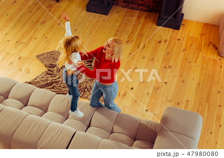 Positive delighted blonde female playing with her daughter 47980080