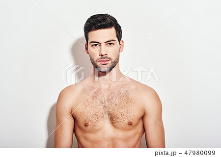 Irresistible man. Handsome man standing shirtless over white background and looking at camera 47980099