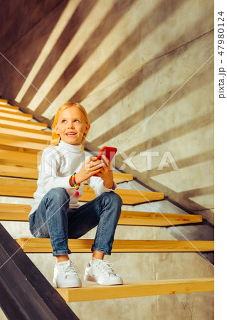 Cheerful blonde kid thinking about summer holidays Cheerful blonde kid thinking about summer holidays 47980124