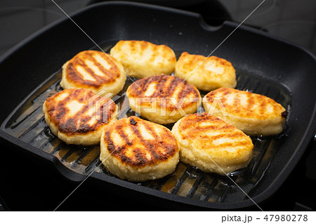 Traditional Russian sweet syrniki cottage cheese pancakes fried in the frying pan Traditional Russian sweet syrniki cottage cheese pancakes fried in the frying pan 47980278
